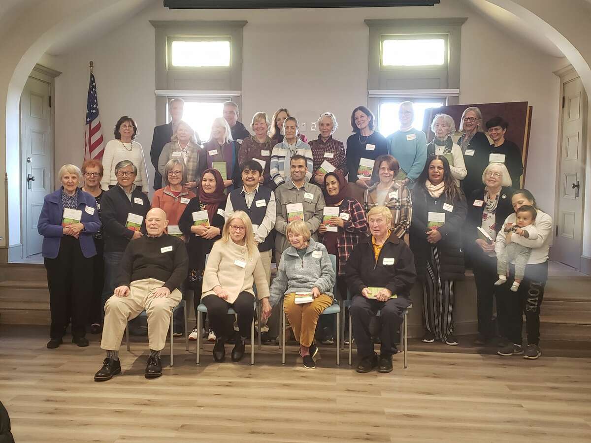 Over 20 Literacy Volunteers on the Green representatives, board members, tutors and students gather in Memorial Hall on the second floor of the New Milford Public Library for the launch of the student-created cookbook "Dishes from Around the World."