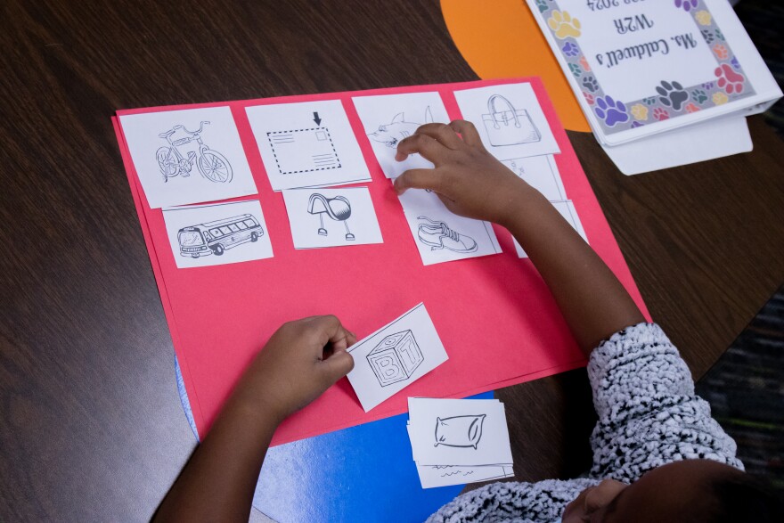 A second grade student at John Burroughs Elementary school matches the beginning sounds of words represented by pictures while teacher Vicky Caldwell