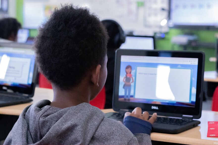 A second grader at John Burroughs Elementary reads sentences prompted by the AI tutoring program, Amira.