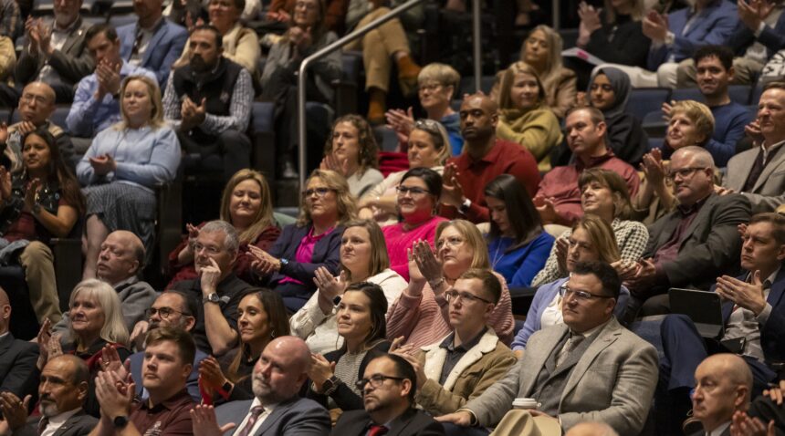 a photo of a crowd of people applauding inside Rudder Theatre.