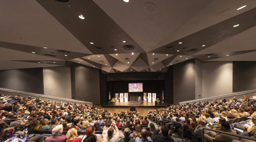 a photo of the crowd inside Rudder Theatre with Interim President Mark A. Welsh III on the stage.